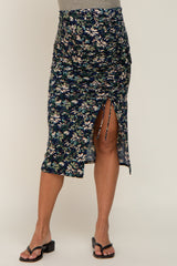 woman wearing a floral maternity midi skirt with side ruching and a slit, styled with black sandals