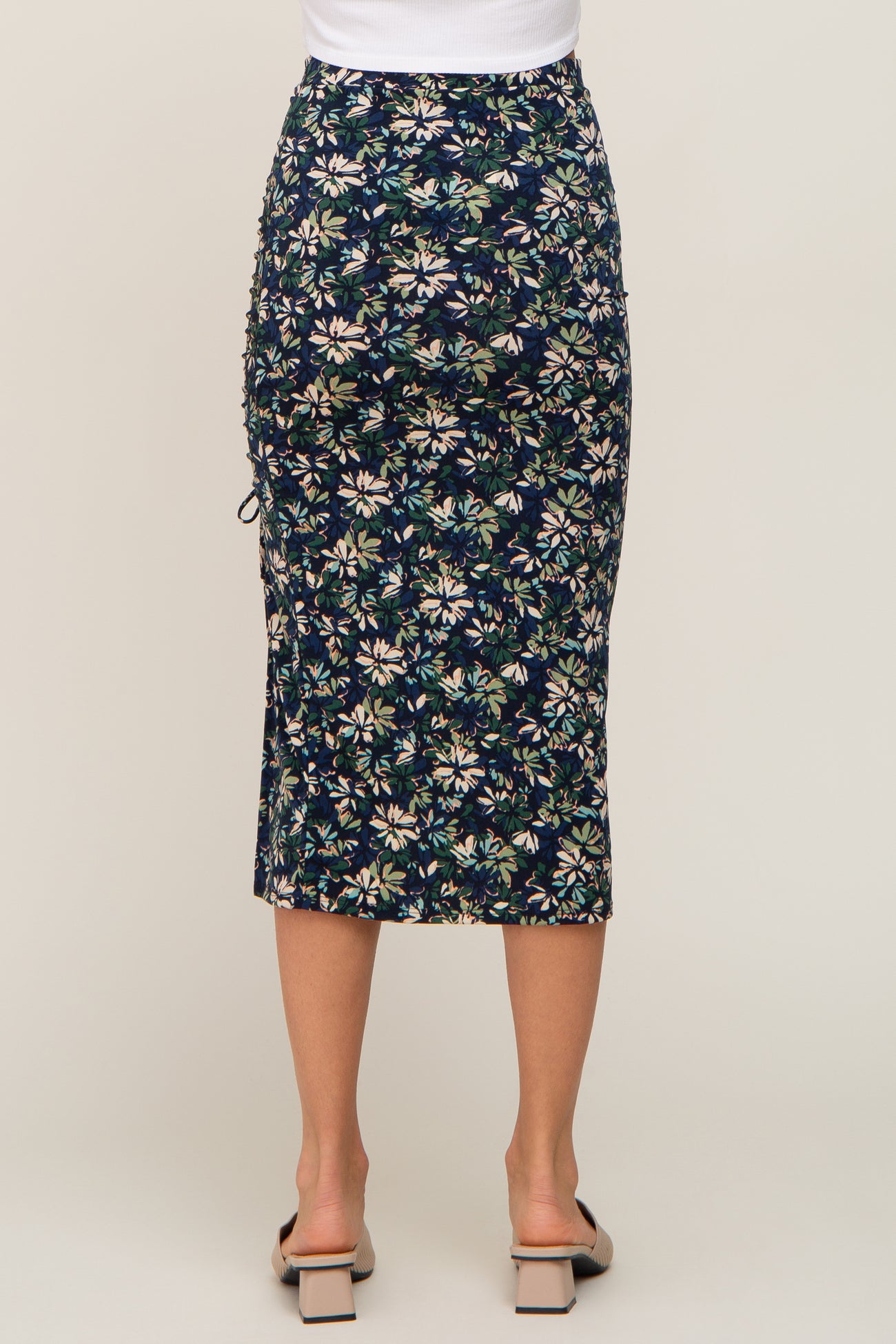 woman wearing a navy floral midi skirt with ruching details at the sides