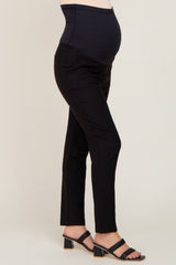 woman wearing black maternity pants with a supportive over-the-bump waistband and a visible baby bump
