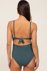 woman wearing a dark green maternity bikini with a back tie detail and ribbed texture