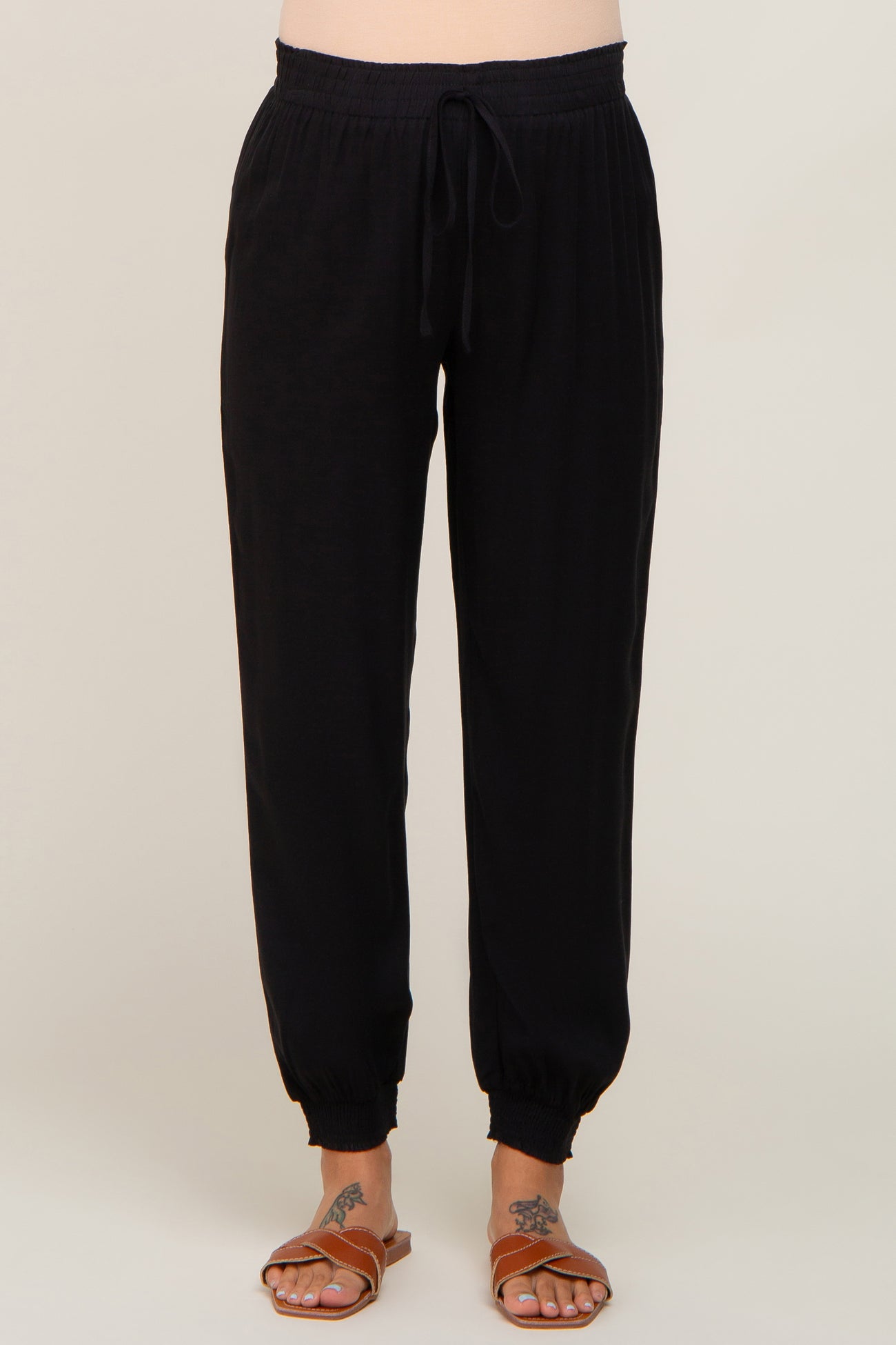 woman wearing black maternity jogger pants with a drawstring waist and elastic cuffs