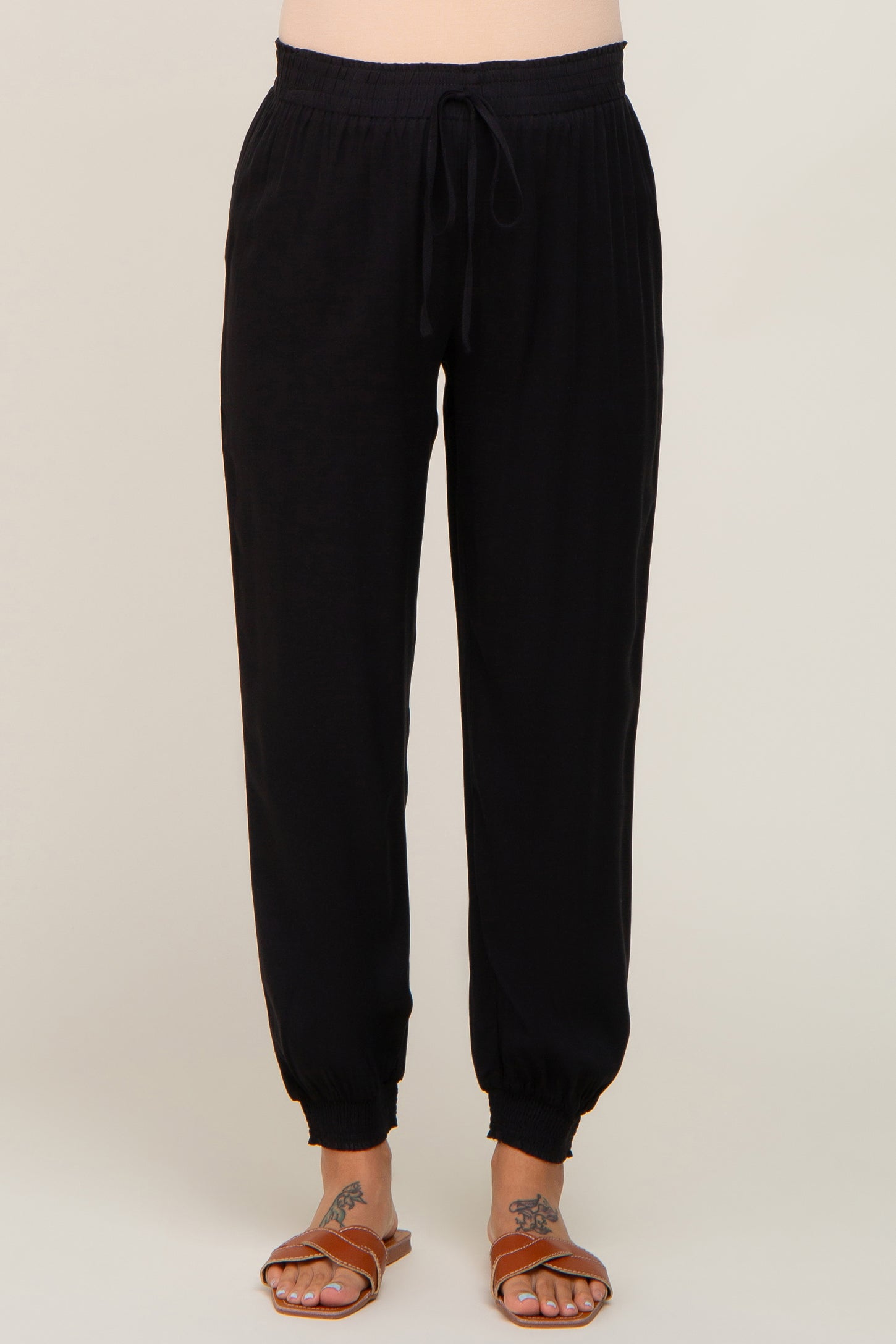 woman wearing black maternity jogger pants with a drawstring waist and elastic cuffs