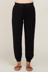 woman wearing black maternity jogger pants with a drawstring waist and elastic cuffs