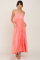 woman wearing a coral pink tiered maxi dress with spaghetti straps and pockets