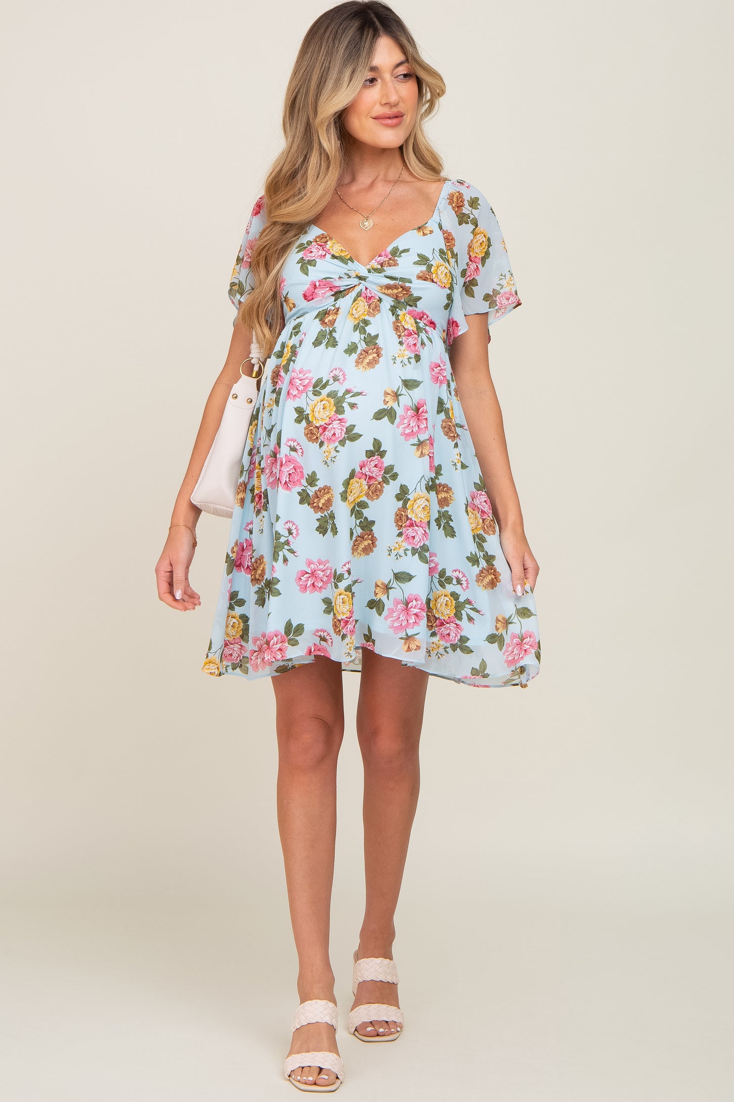 pregnant woman wearing light blue floral maternity dress with short sleeves and v-neckline