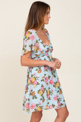 woman wearing light blue floral print mini dress with flutter sleeves and v-neckline