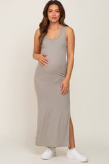woman wearing a striped beige maternity maxi dress and holding her baby bump
