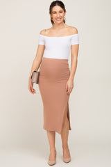 Pregnant woman in white off-the-shoulder top and tan ribbed maternity midi skirt with side slit