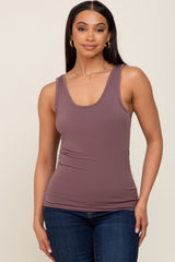 woman wearing a mauve sleeveless tank top paired with dark blue jeans