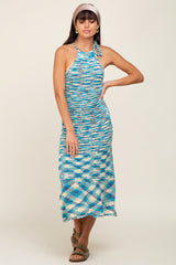 woman wearing a multicolored knit halter neck maxi dress with a fitted silhouette and sandals