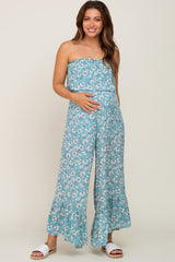 pregnant woman wearing a blue floral strapless maternity jumpsuit with wide legs and ruffle hem