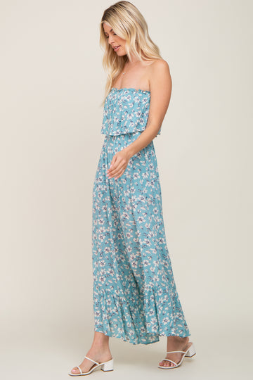 blonde woman wearing a blue floral strapless maxi dress and white block heel sandals