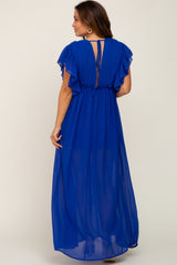 woman wearing a royal blue maternity maxi dress with flutter sleeves and a cinched waist, showcasing a tie-back detail