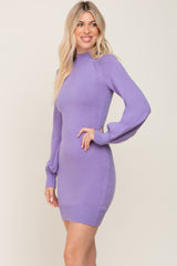 Woman wearing a purple long sleeve mock neck knit mini dress with balloon sleeves