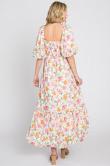 woman wearing a floral print maxi dress with puff sleeves and a square back, standing with her back to the camera