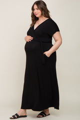 Pregnant woman wearing a black short sleeve wrap maternity maxi dress with pockets and a waist tie