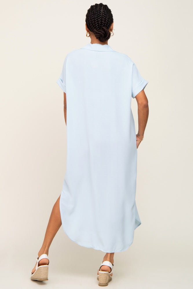 Back view of a woman wearing a light blue short-sleeve midi shirt dress and white wedge sandals