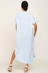 Back view of a woman wearing a light blue short-sleeve midi shirt dress and white wedge sandals
