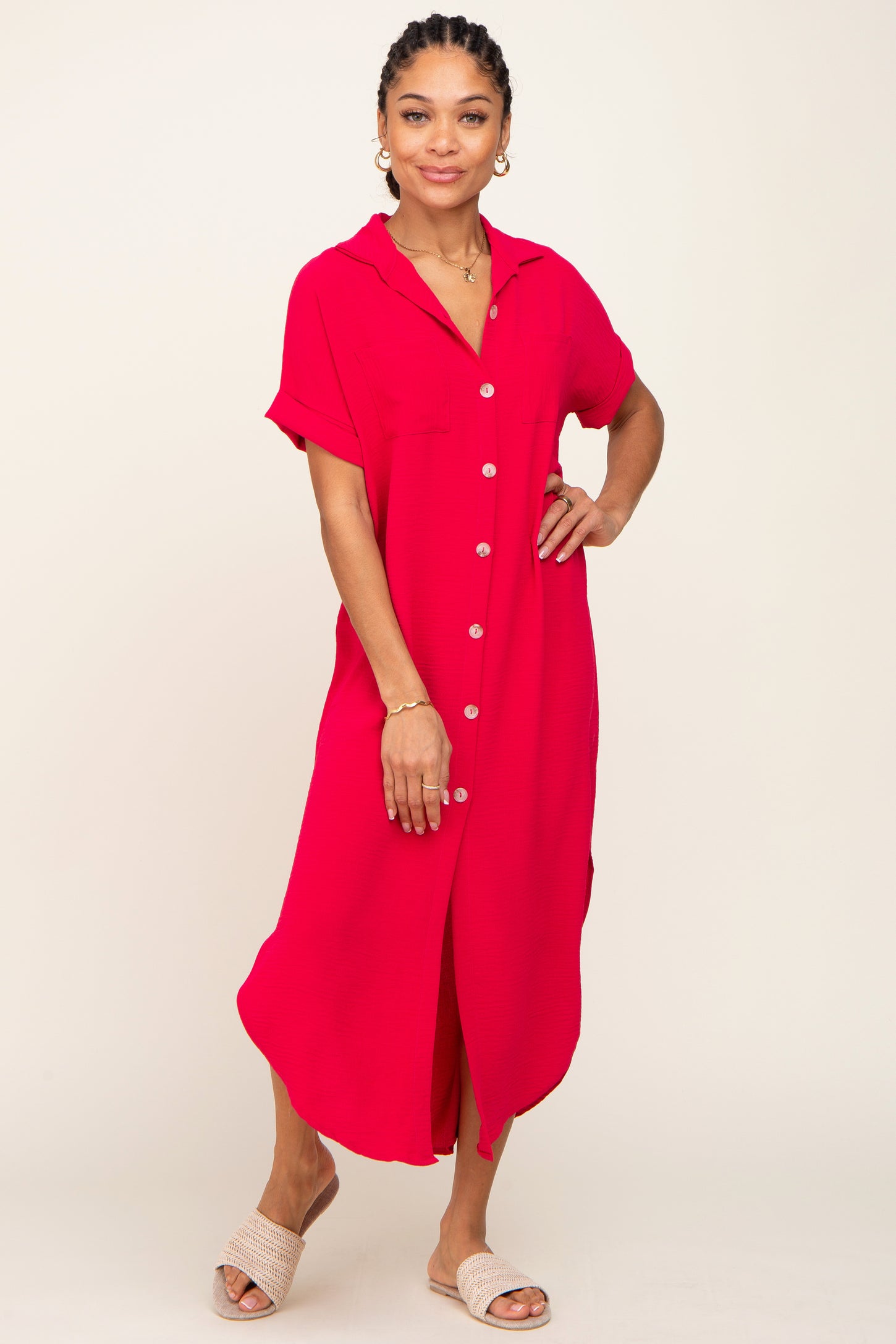 Woman wearing a bright pink short-sleeve button-down midi shirt dress with woven slide sandals