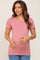 Pregnant woman wearing a pink short sleeve maternity t-shirt and blue jeans holding her baby bump