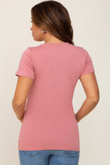 woman wearing a dusty rose short sleeve maternity top with a fitted style, showing the back view