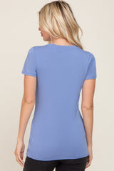 woman wearing a fitted light blue t-shirt with short sleeves, viewed from the back