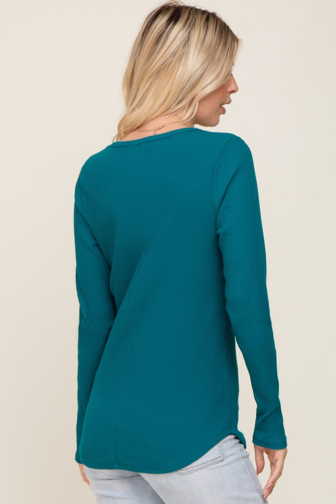woman wearing a teal long sleeve ribbed top seen from the back, styled with light blue jeans