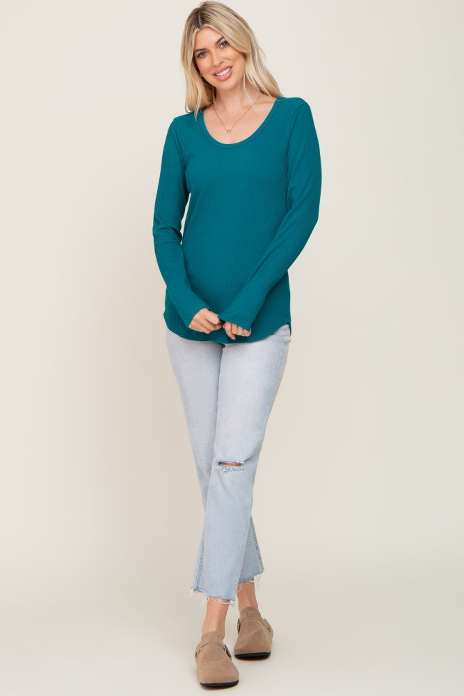 woman wearing a teal ribbed long sleeve top with a scoop neckline and light wash ripped jeans