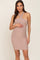 woman wearing a light brown ribbed maternity dress with a crisscross halter neckline and baby bump visible