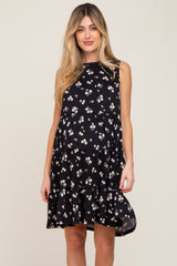 woman wearing a black sleeveless tiered maternity dress with a white floral print