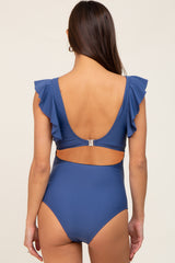Back view of woman wearing a blue one-piece swimsuit with ruffle sleeves and a cutout back design