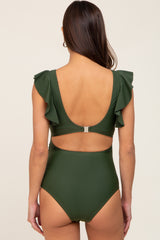 woman wearing a dark green maternity one-piece swimsuit with ruffle sleeves and an open back design