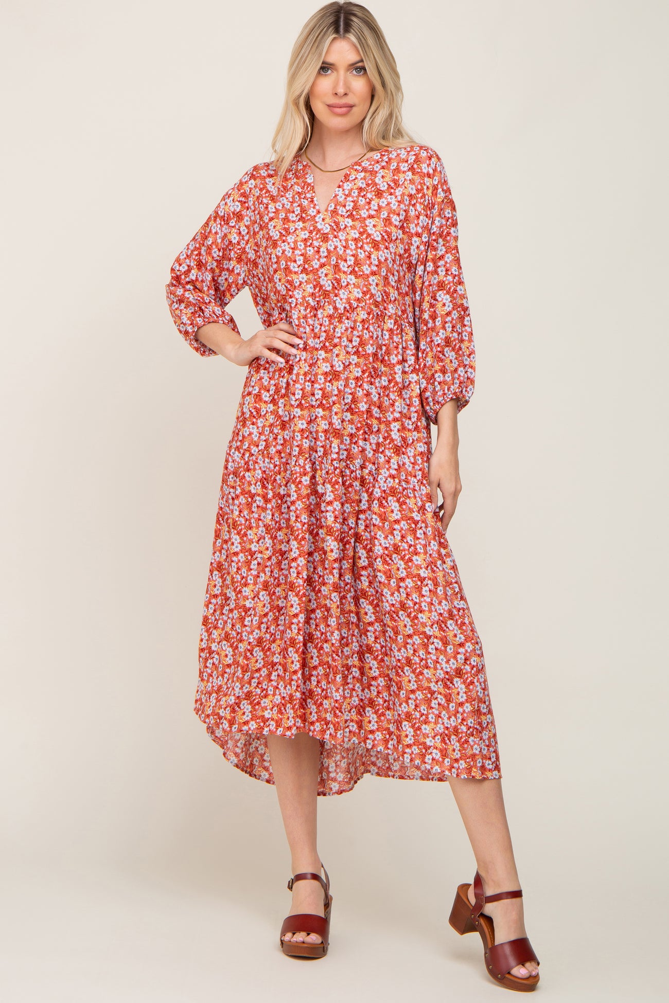 woman wearing a red floral tiered midi dress with long sleeves and brown platform sandals