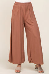 woman wearing mauve wide leg palazzo pants with elastic waistband and tan block heel sandals