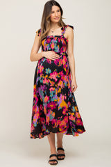 pregnant woman wearing a colorful abstract print smocked maternity midi dress with tie straps