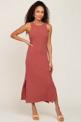 woman wearing a rust colored sleeveless maxi dress with a side slit and a relaxed fit