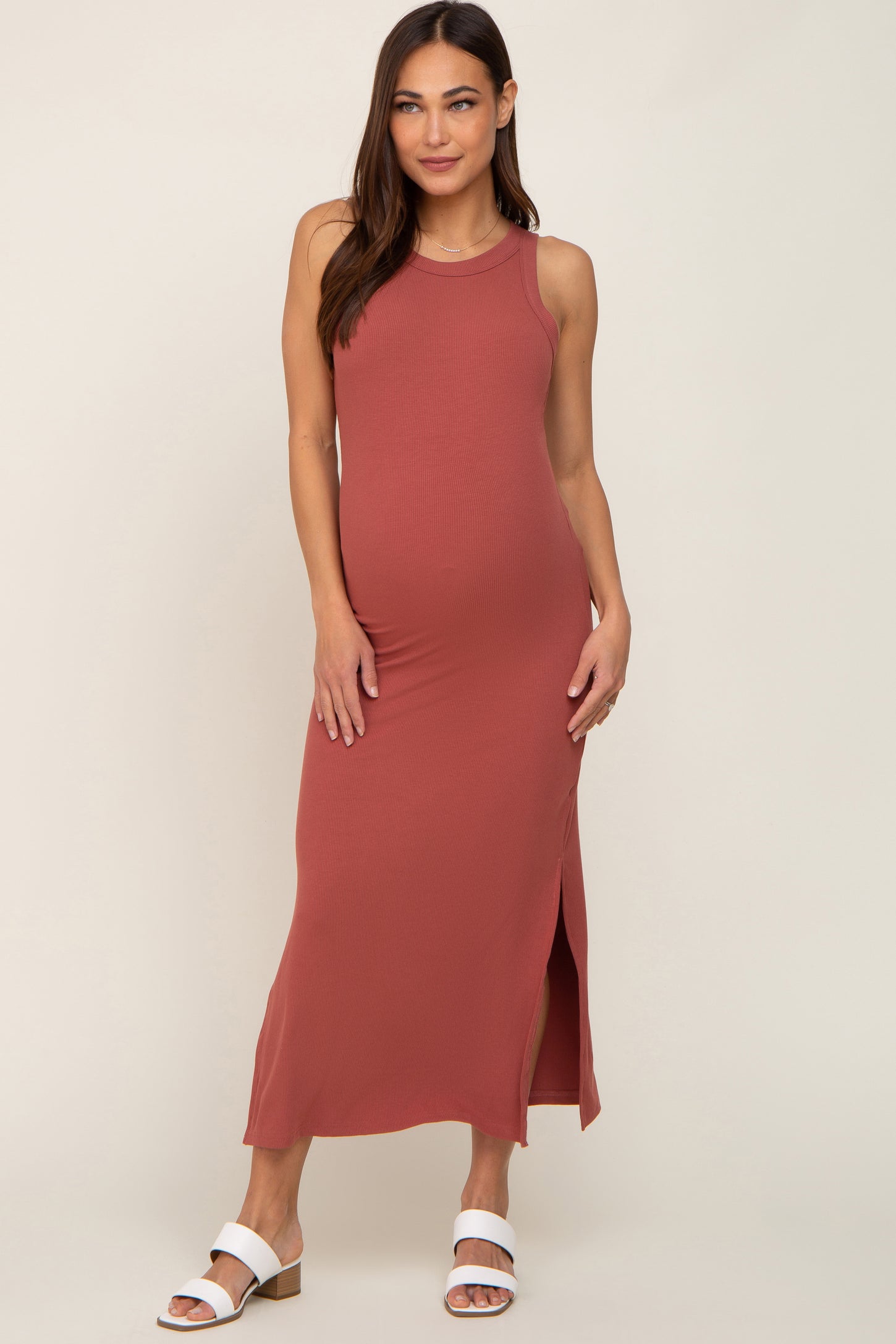 woman wearing a dusty rose maternity maxi dress with a side slit and showing her baby bump