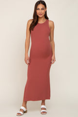woman wearing a rust colored ribbed maternity maxi dress and showcasing her baby bump