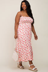 smiling woman in a pink floral smocked midi dress holding a white handbag and wearing wedge sandals