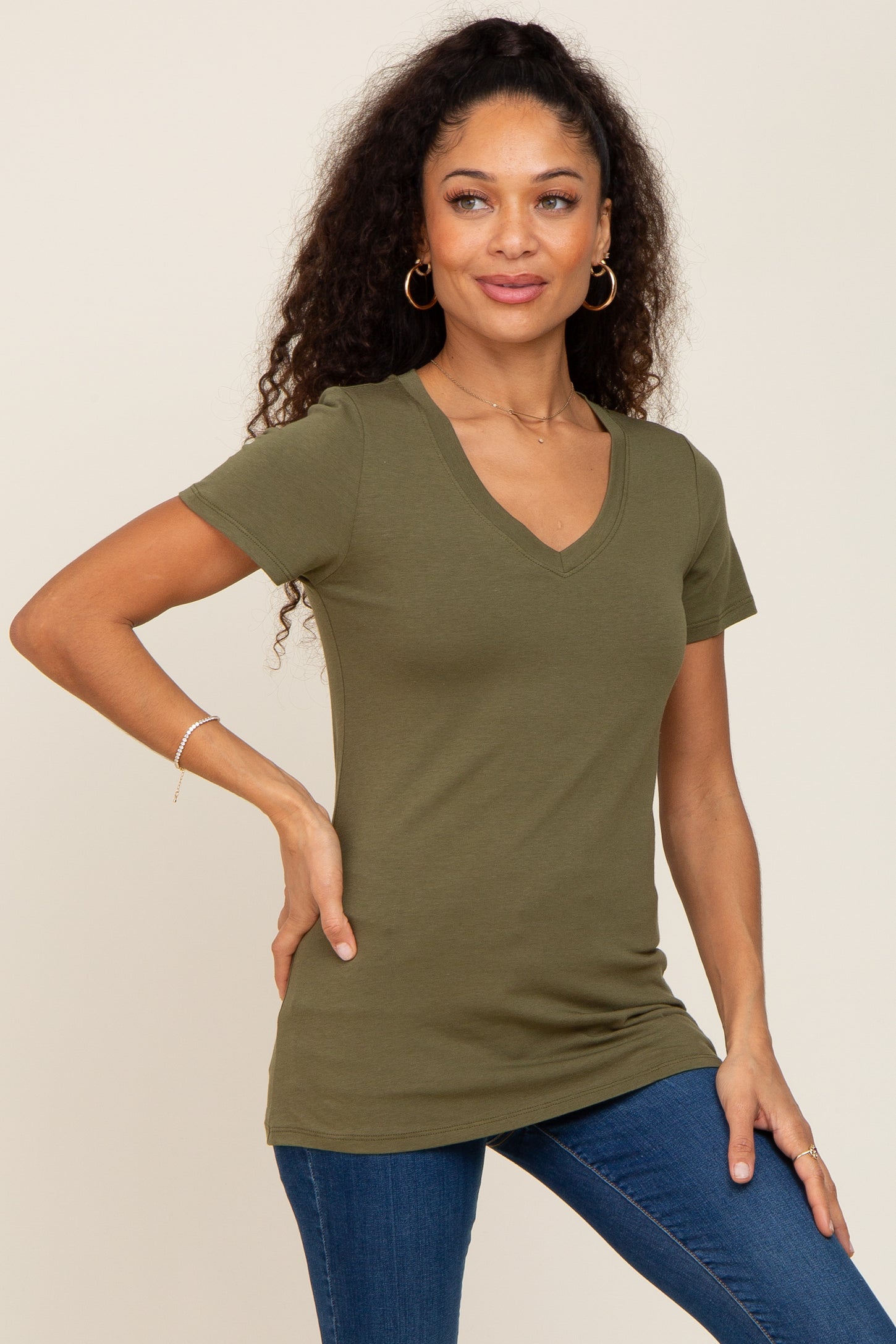 woman wearing olive green v-neck short sleeve t-shirt and blue jeans