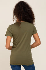 Back view of a woman with long curly hair wearing an olive green short sleeve t-shirt and blue jeans