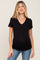 woman wearing a black v-neck maternity top and fitted jeans, showing her baby bump