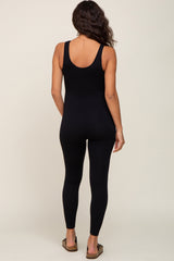 woman wearing a black maternity jumpsuit with a fitted silhouette and open back design