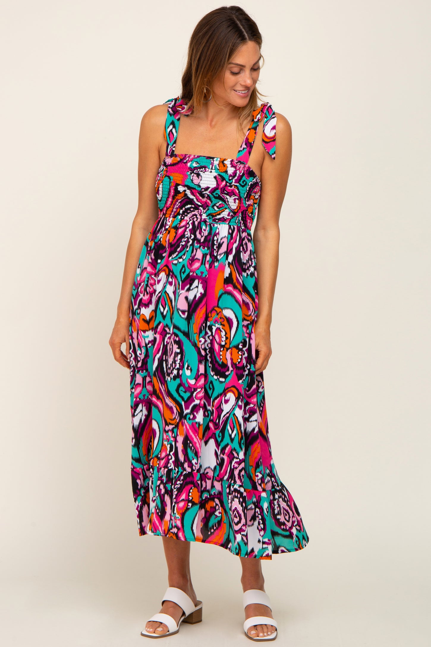 woman wearing a colorful printed maxi dress with square necklines and thick straps
