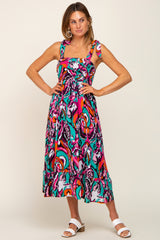 woman wearing a colorful patterned midi dress with thick straps and a ruffled hem