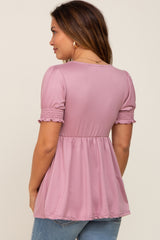 woman wearing a lilac maternity top with smocked short sleeves and a flowy hem