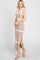 woman wearing a beige striped maxi dress with a scoop neckline and side slit, standing in profile