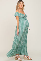 woman wearing a green and white striped off-the-shoulder maternity dress with a baby bump visible