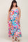 woman wearing a colorful abstract print maxi dress with spaghetti straps and white slide sandals