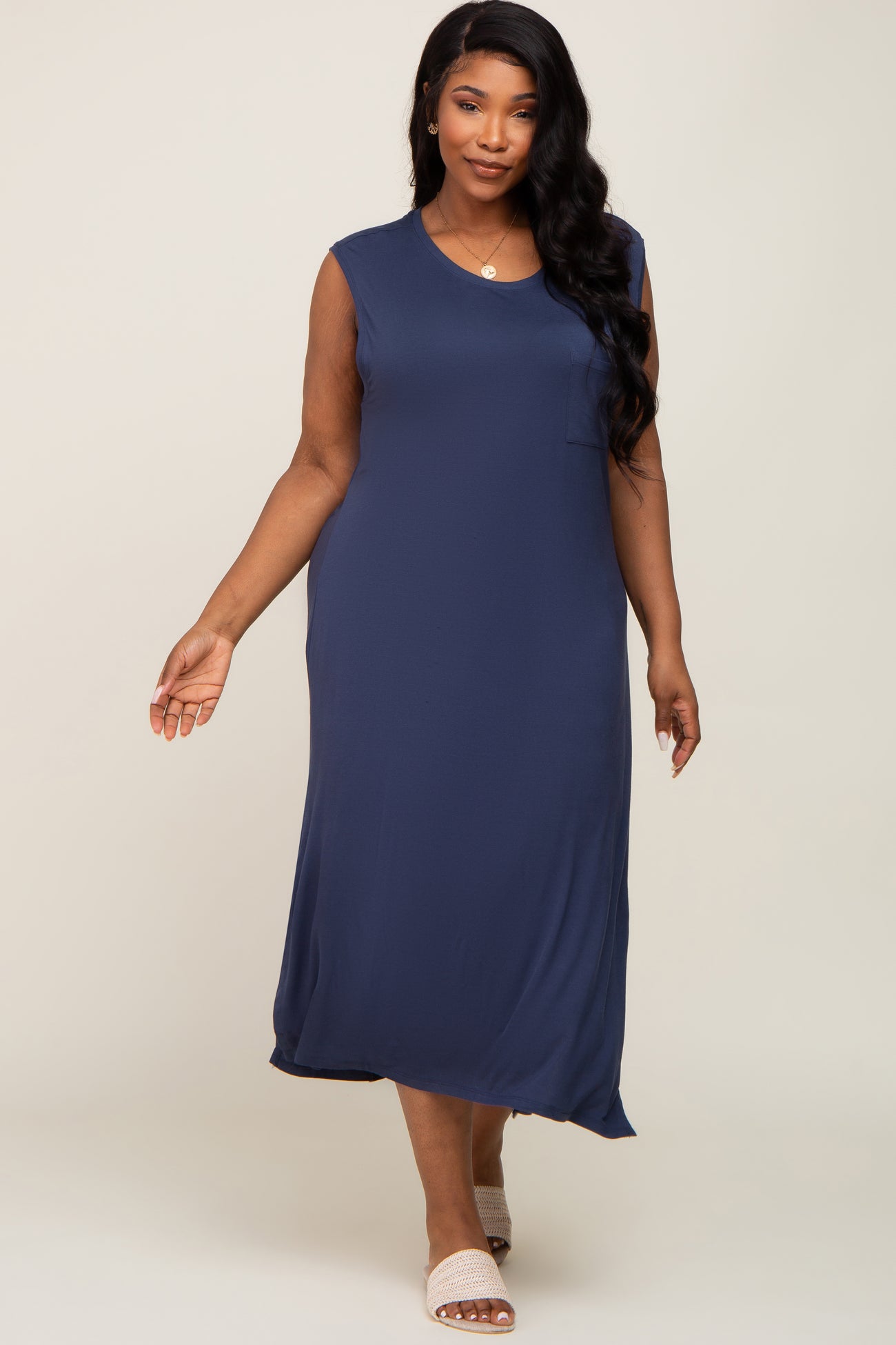 woman wearing a navy blue sleeveless plus size maxi dress with a pocket and a relaxed fit